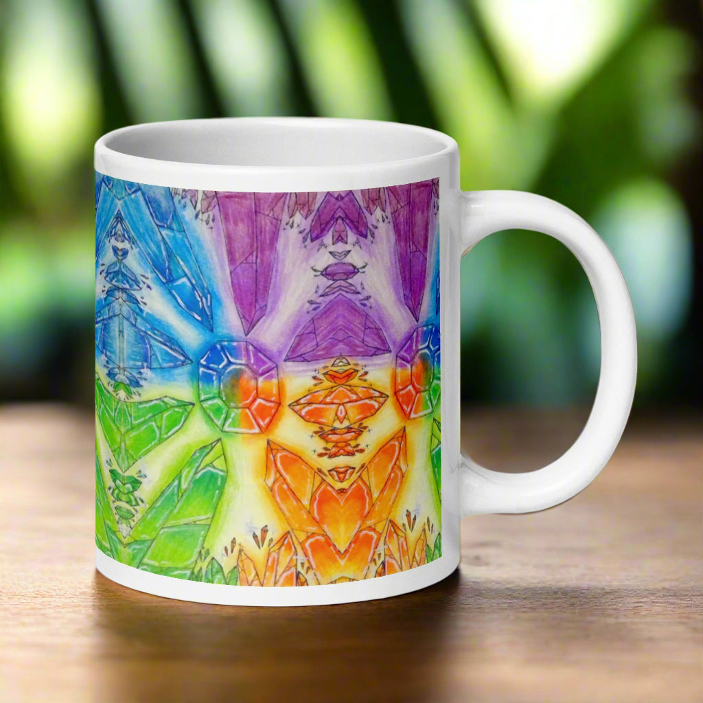 White mug with a colorful abstract design featuring geometric shapes and vibrant colors on a white background.